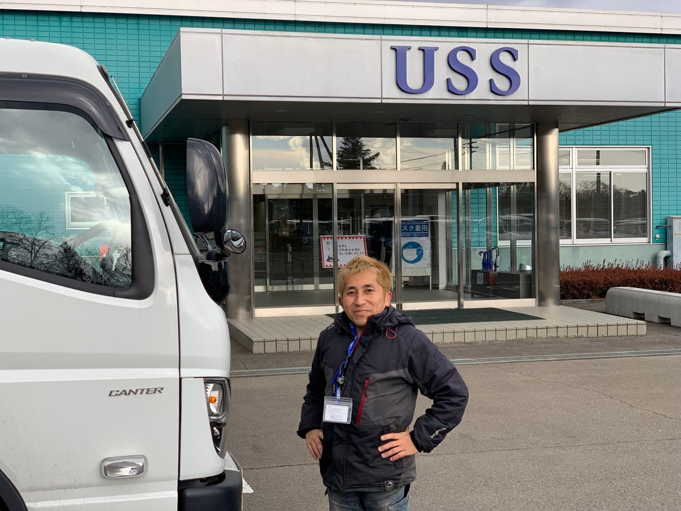 Ito Tadadaka standing outside a USS auction hall next to a transport truck