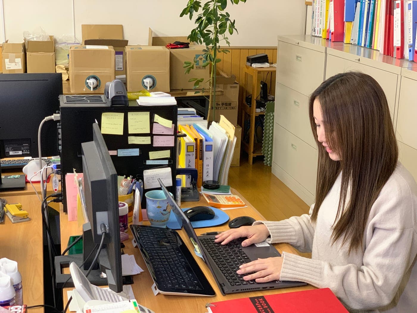 Yuka Abe working at her desk in the office